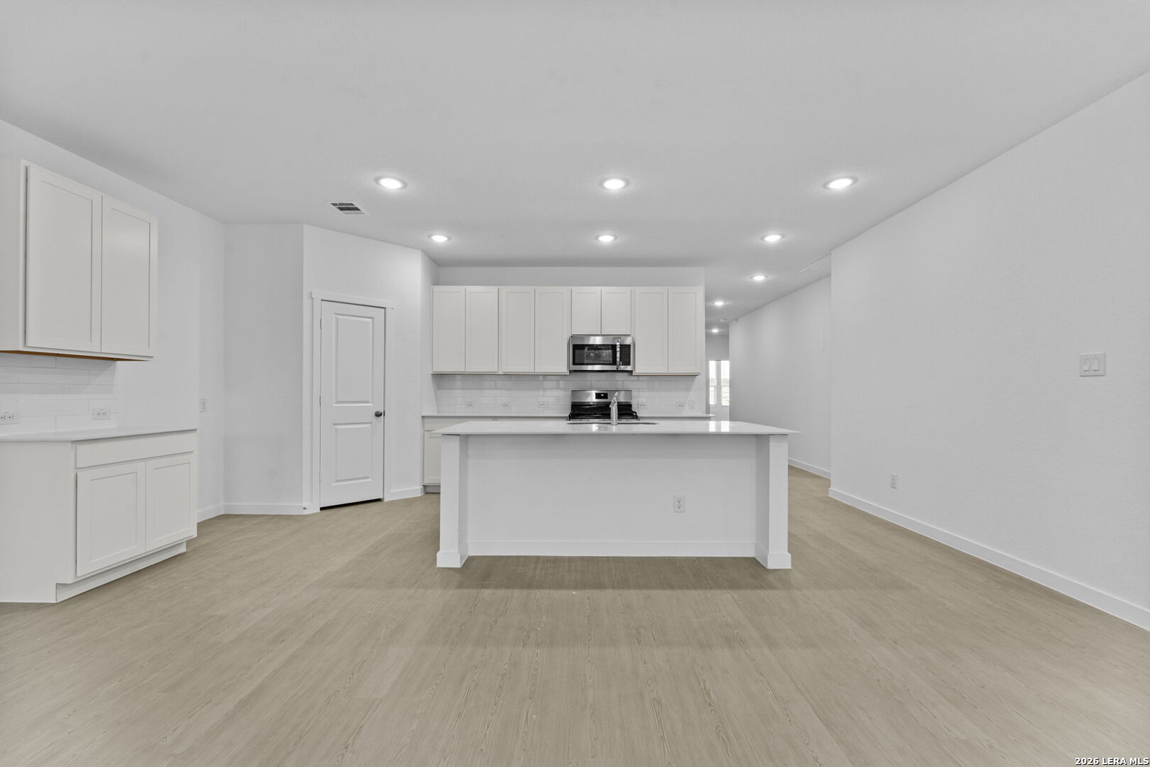 2299 Fort Davis Pass Marion, TX 78124 - Photo 17 of 26 a large white kitchen with kitchen island a sink a refrigerator and white cabinets