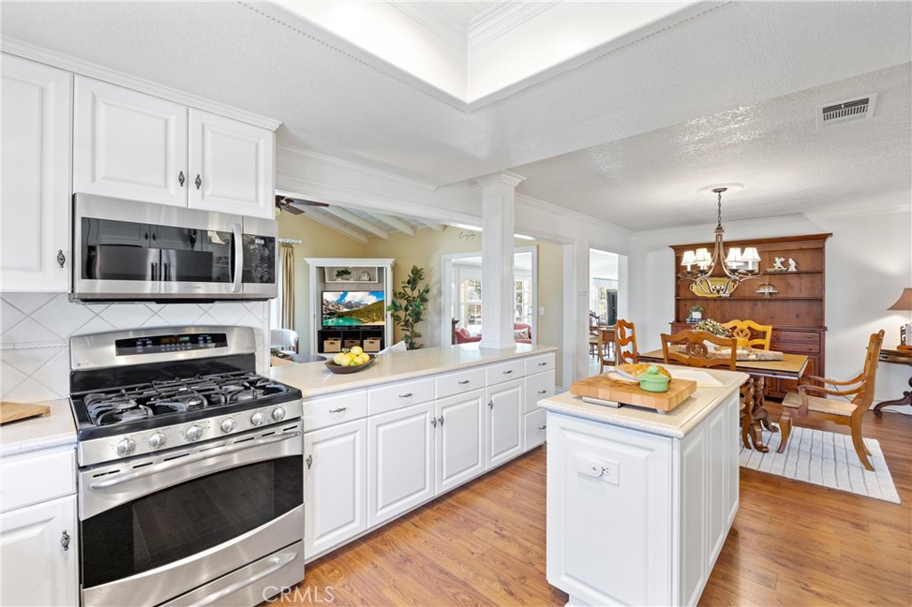 3527 Bluff Street Norco, CA 92860 - Photo 15 of 53 a kitchen with stainless steel appliances a stove cabinets and wooden floor