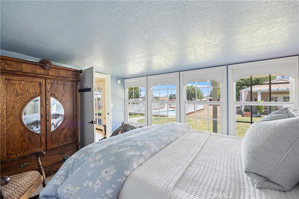 3527 Bluff Street Norco, CA 92860 - Photo 25 of 53 a bedroom with a bed a mirror on dresser and a large window