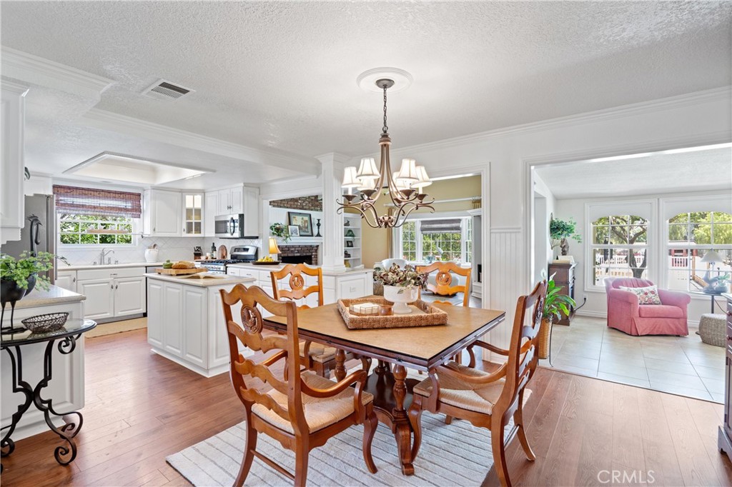 3527 Bluff Street Norco, CA 92860 - Photo 10 of 53 a dining room with furniture a chandelier and wooden floor