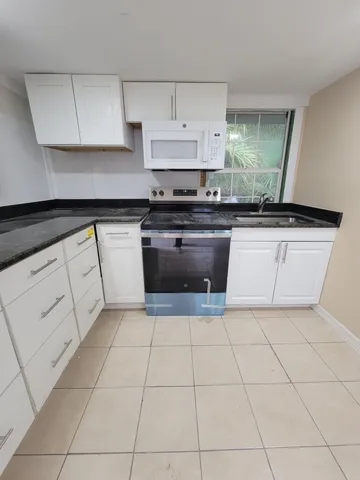 a kitchen with stainless steel appliances a sink stove and cabinets