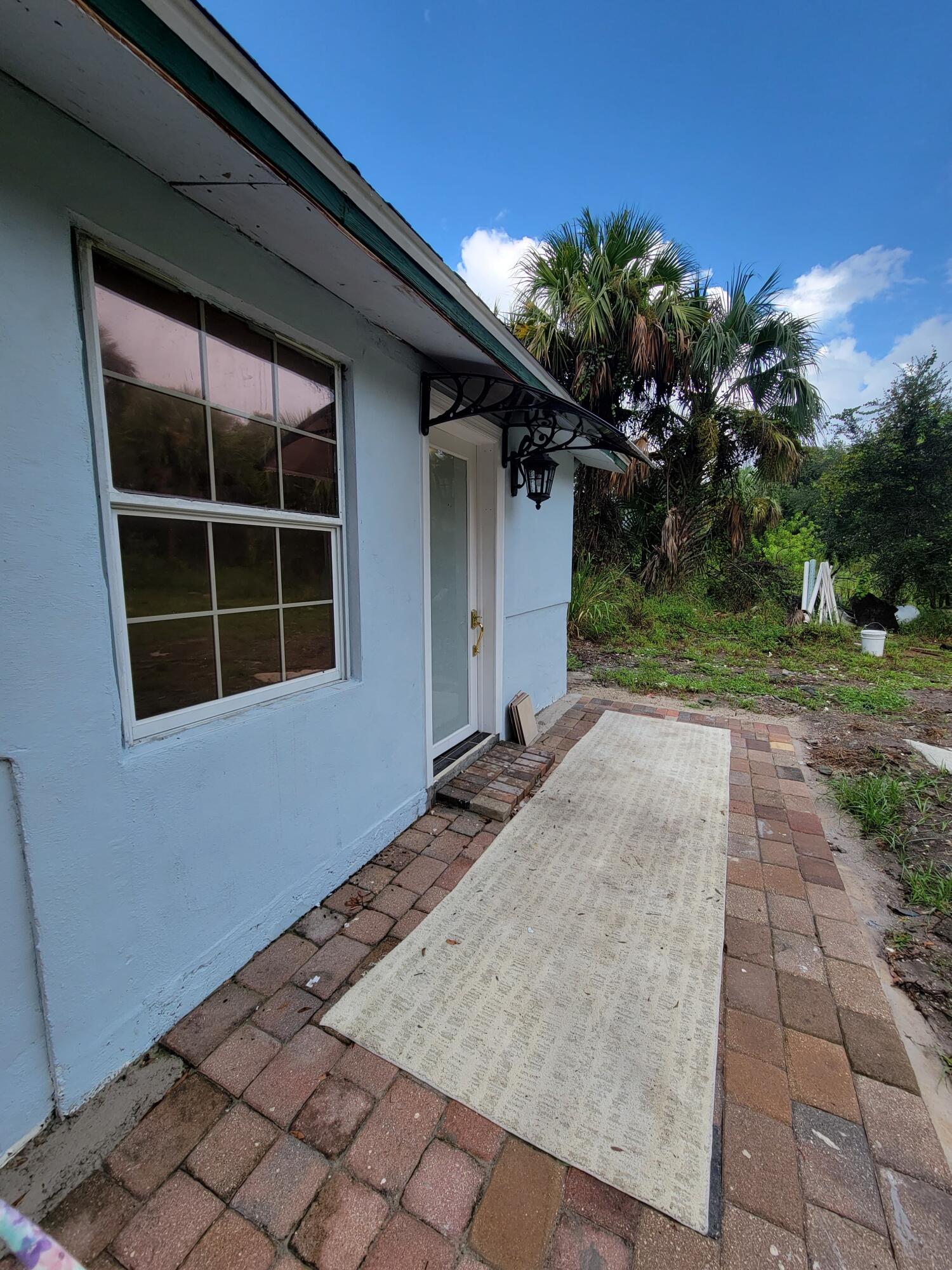 5728 St Lucie Boulevard, Unit REAR HOUSE Fort Pierce, FL 34946 - Photo 2 of 22 a front view of a house with a yard