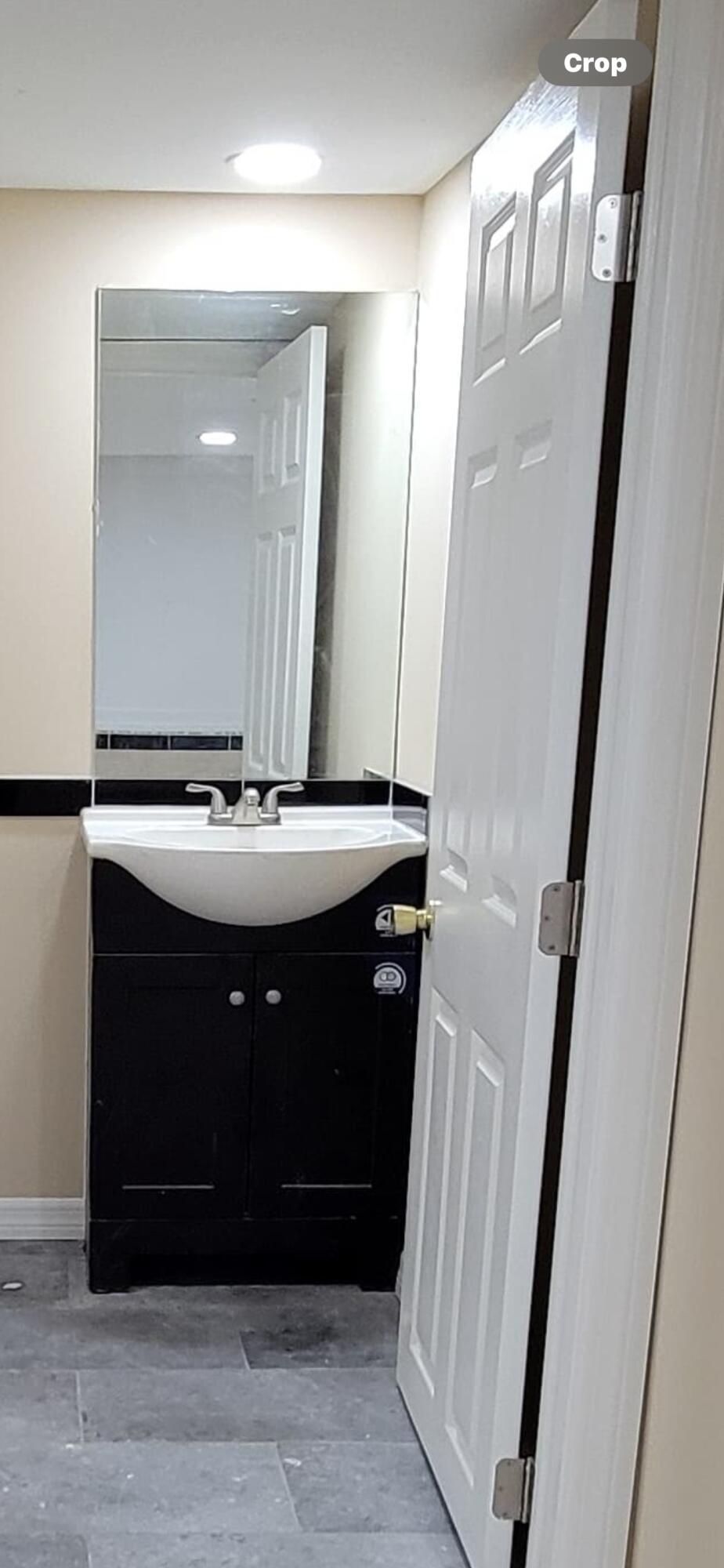 5728 St Lucie Boulevard, Unit REAR HOUSE Fort Pierce, FL 34946 - Photo 5 of 22 a bathroom with a sink a mirror and vanity