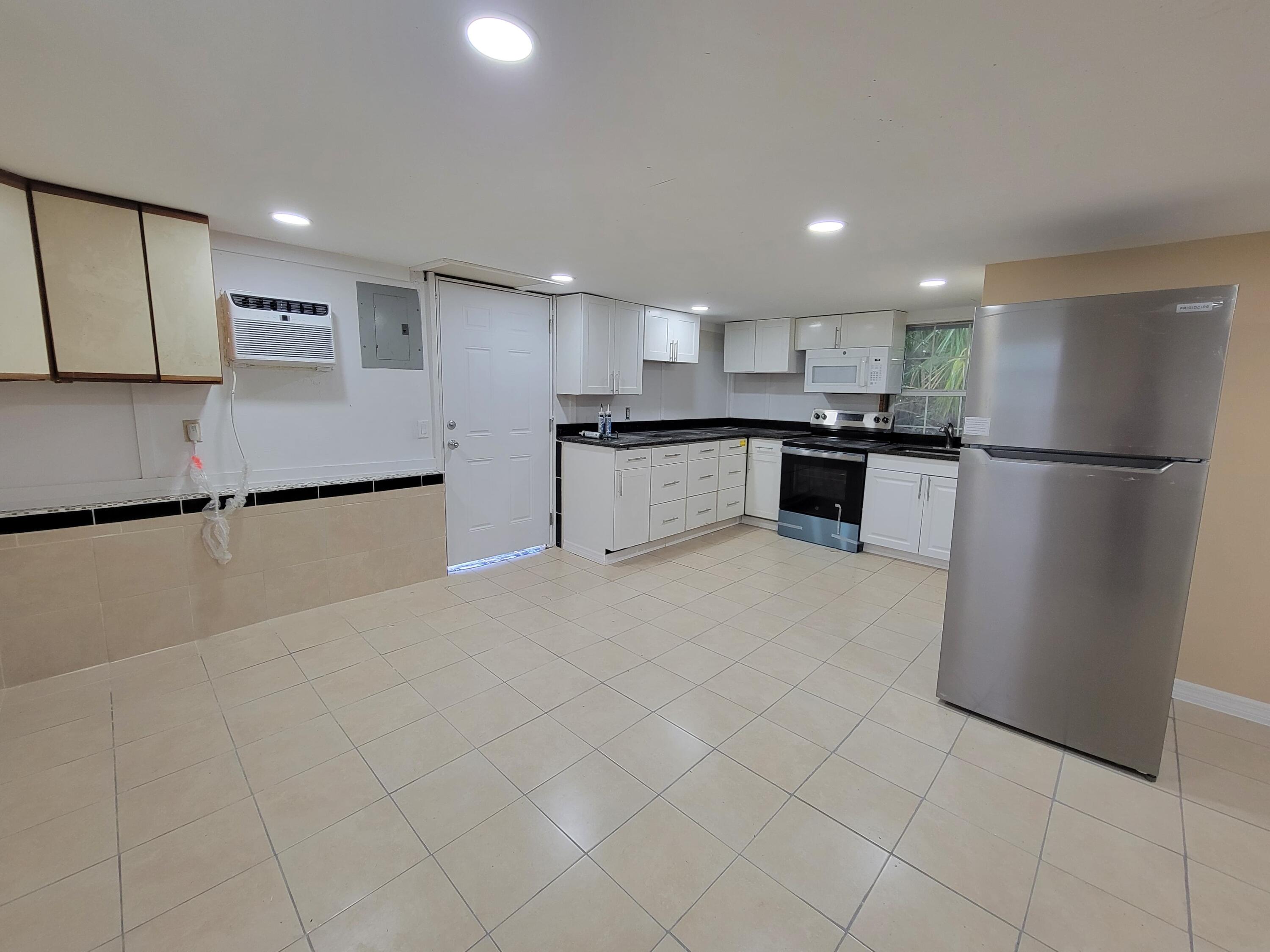 5728 St Lucie Boulevard, Unit REAR HOUSE Fort Pierce, FL 34946 - Photo 7 of 22 a kitchen with stainless steel appliances granite countertop a refrigerator sink and white cabinets