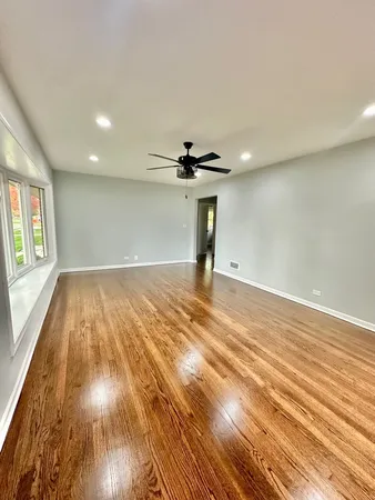a view of empty room with wooden floor