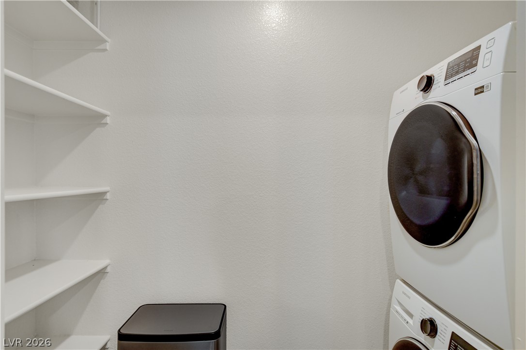 6924 Spicy Merlot Street North Las Vegas, NV 89086 - Photo 38 of 83 A dedicated laundry area provides practical, organized utility with convenient stacked appliances and built-in shelving.