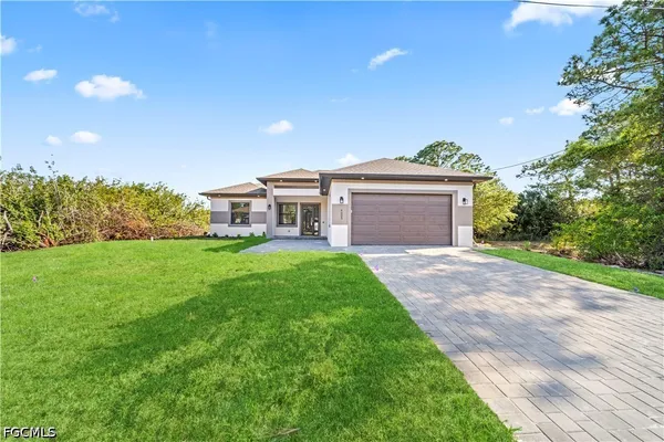 a front view of a house with a garden and yard