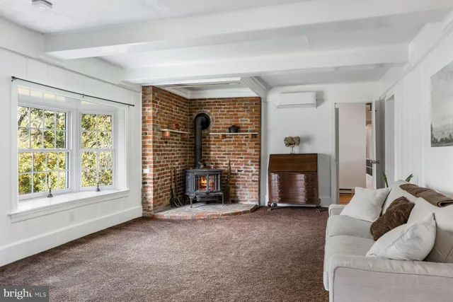 a view of an empty room with a fireplace and a window