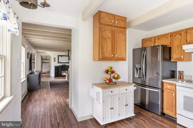 a view of a white house with a yard and lawn chairs