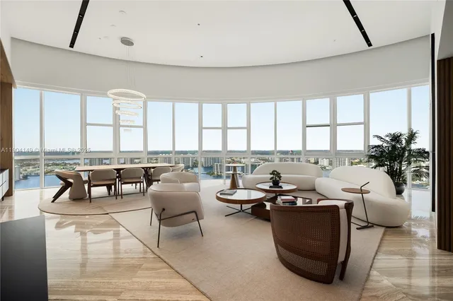a living room with furniture and floor to ceiling windows