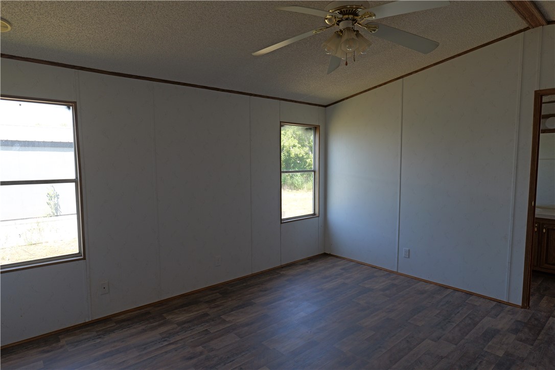 732 A Rogers Street Normangee, TX 77871 - Photo 3 of 8 an empty room with wooden floor fan and windows