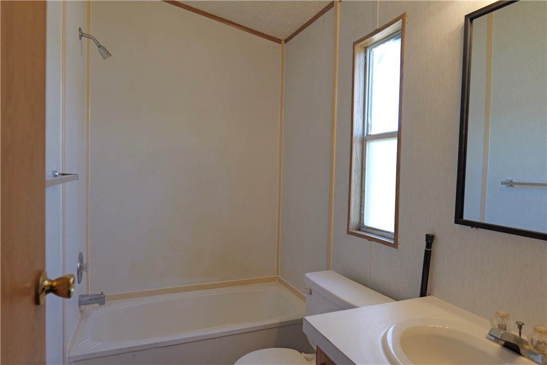 732 A Rogers Street Normangee, TX 77871 - Photo 7 of 8 a bathroom with a toilet and a tub