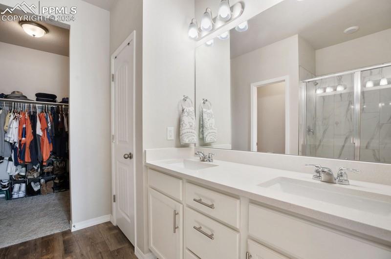 10480 Summer Ridge Drive Peyton, CO 80831 - Photo 11 of 30 a bathroom with double vanity sinks a vanity and a mirror