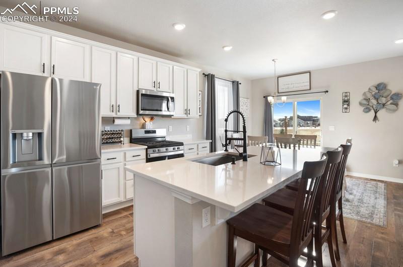 10480 Summer Ridge Drive Peyton, CO 80831 - Photo 22 of 30 a kitchen with refrigerator a sink dining table and chairs