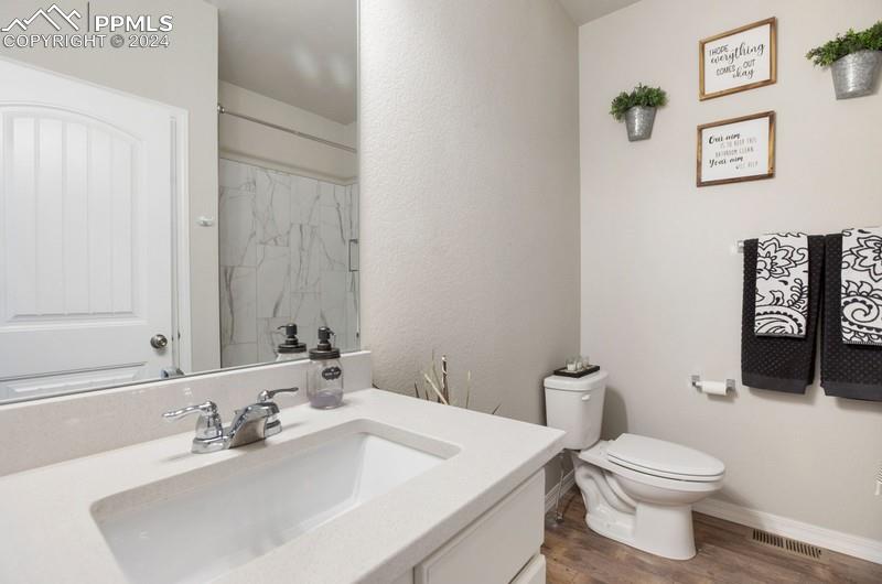 10480 Summer Ridge Drive Peyton, CO 80831 - Photo 23 of 30 a bathroom with a sink a toilet and a mirror