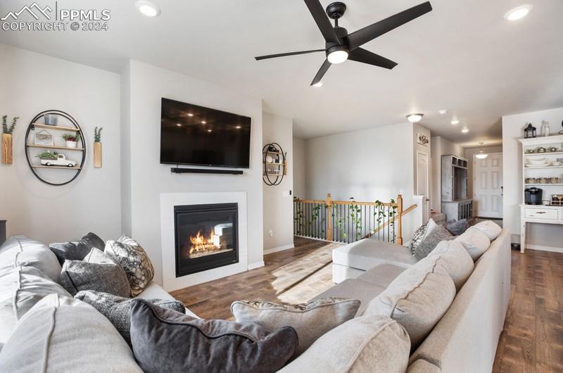 10480 Summer Ridge Drive Peyton, CO 80831 - Photo 6 of 30 a living room with furniture a fireplace and a flat screen tv