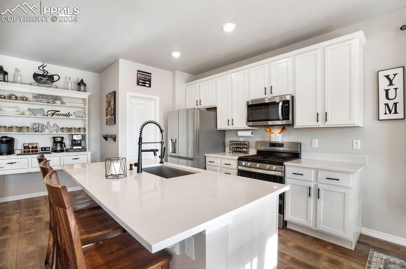 10480 Summer Ridge Drive Peyton, CO 80831 - Photo 9 of 30 a kitchen with stainless steel appliances granite countertop a stove top oven a sink a dining table and chairs with wooden floor