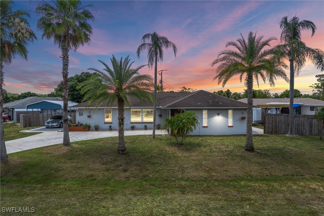 2551 Barcelona Avenue Fort Myers, FL 33905 - Photo 2 of 41 a view of a house with a yard and palm trees