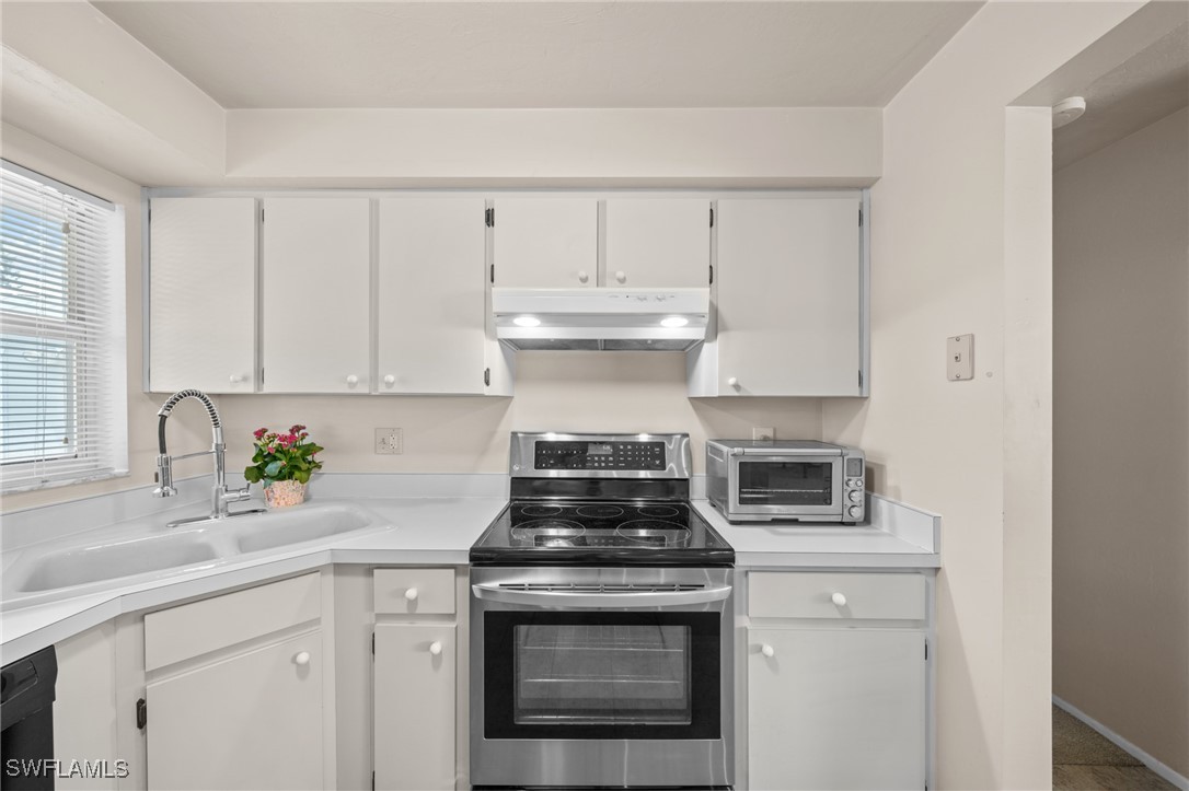 2551 Barcelona Avenue Fort Myers, FL 33905 - Photo 9 of 41 a kitchen with stainless steel appliances granite countertop white cabinets and a window