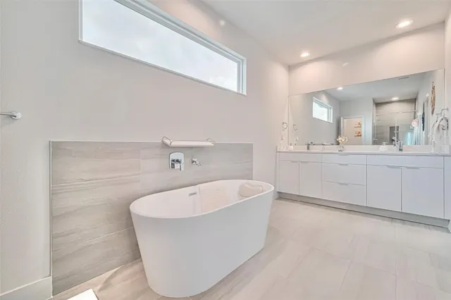 a white bath tub sitting in a bathroom with a sink