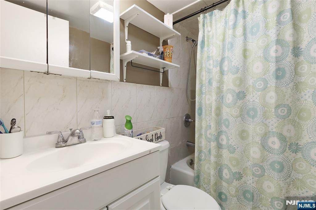 274 Goffle Road Hawthorne, NJ 07506 - Photo 19 of 31 a bathroom with a sink a toilet and shower curtain
