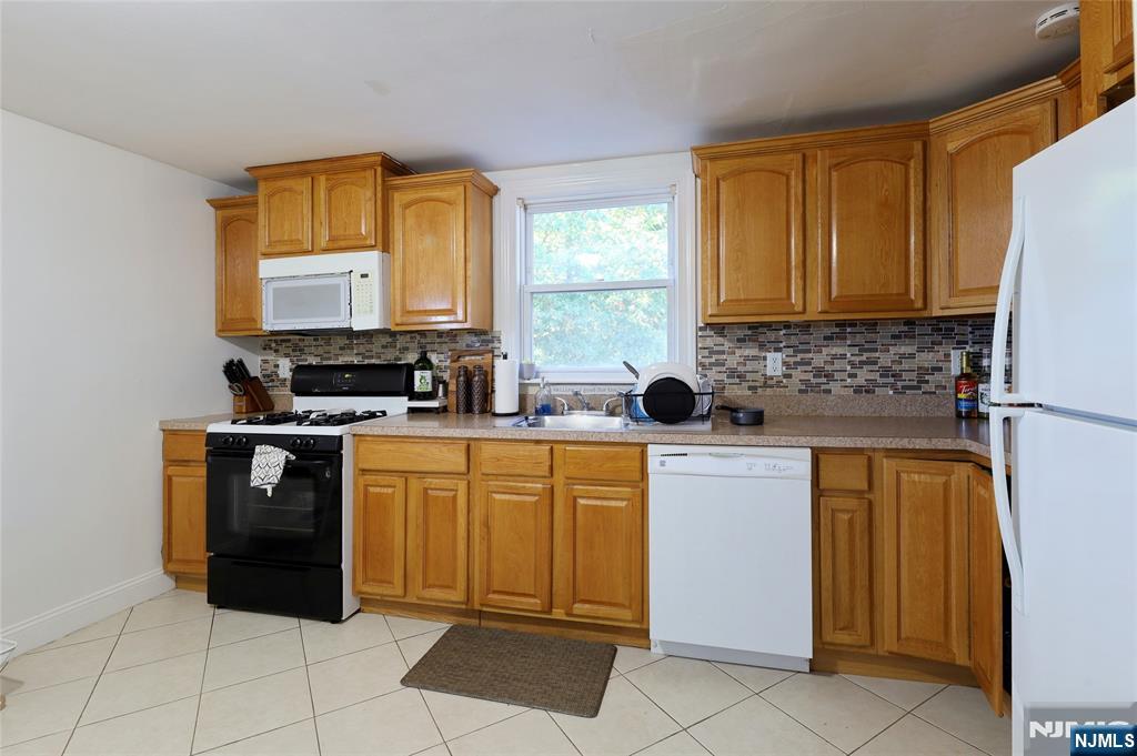274 Goffle Road Hawthorne, NJ 07506 - Photo 22 of 31 a kitchen with stainless steel appliances a stove sink and cabinets