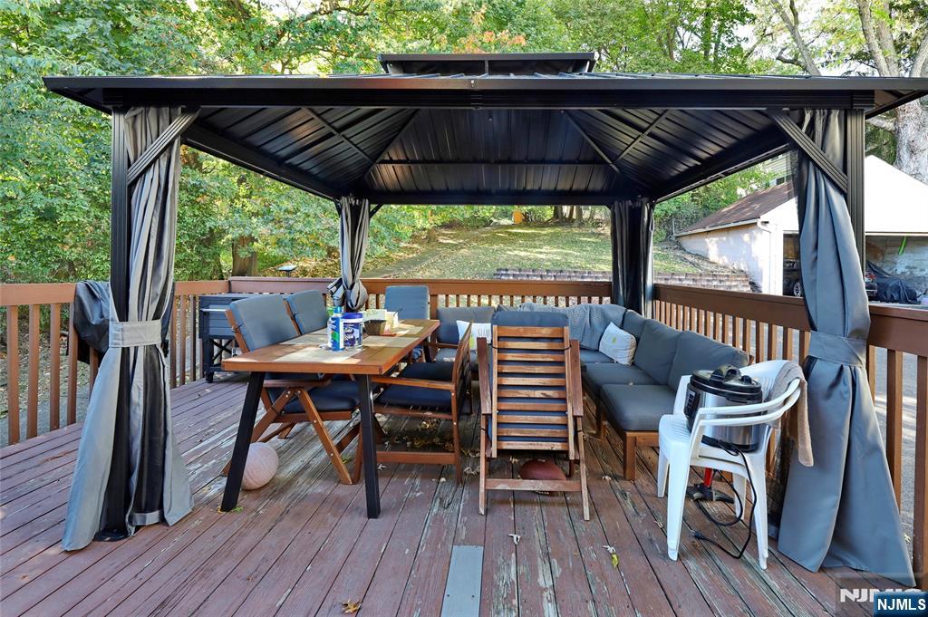 274 Goffle Road Hawthorne, NJ 07506 - Photo 8 of 31 a patio with wooden floor a yard a table and chairs