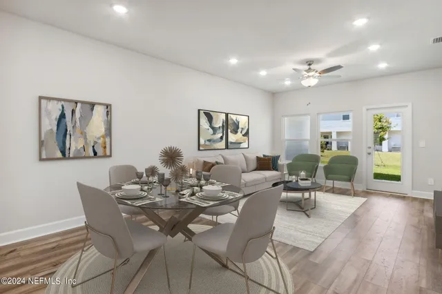 a kitchen with granite countertop white cabinets stainless steel appliances and a wooden floor