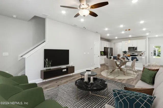 a living room with furniture a flat screen tv and a large window