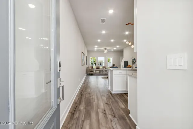 a living room with furniture a wooden floor and a chandelier