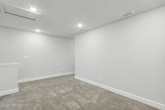 a front view of multi story residential apartment building with yard and sign board