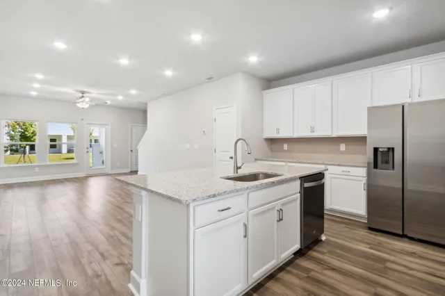 a living room with furniture and a flat screen tv with wooden floor