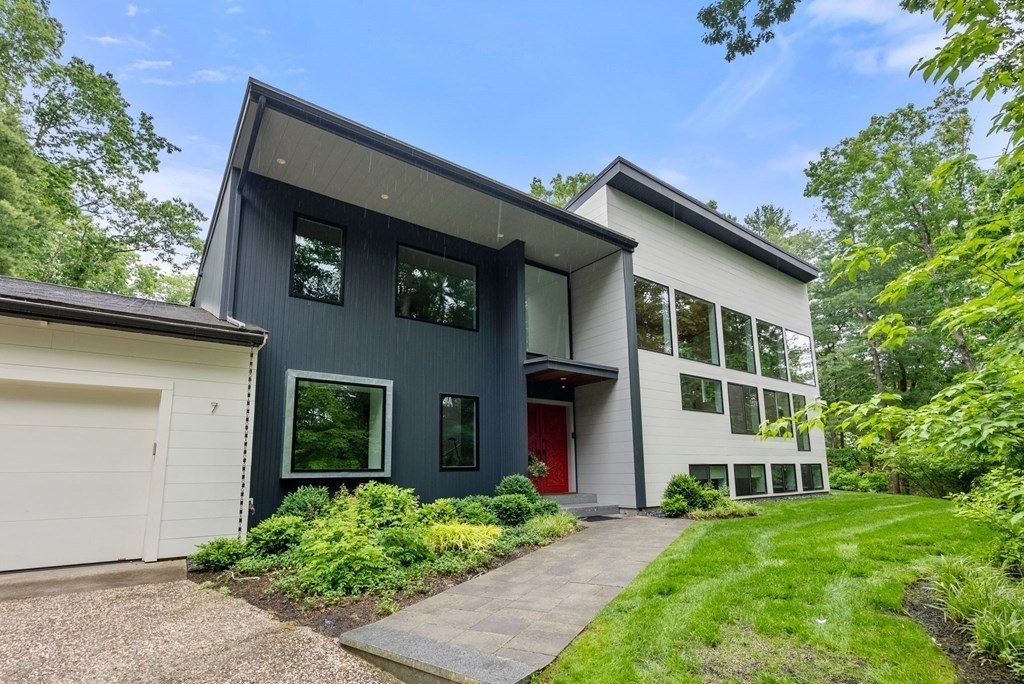a front view of a house with a yard and trees