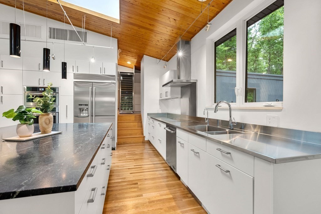 7 Spruce Hill Road Weston, MA 02493 - Photo 12 of 40 a large white kitchen with kitchen island a large window a sink and stainless steel appliances