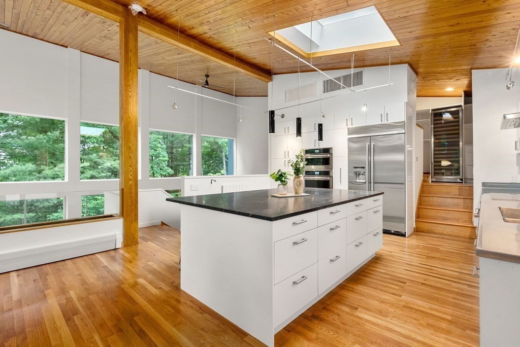 7 Spruce Hill Road Weston, MA 02493 - Photo 10 of 40 a kitchen with stainless steel appliances kitchen island granite countertop a large counter top and wooden floors