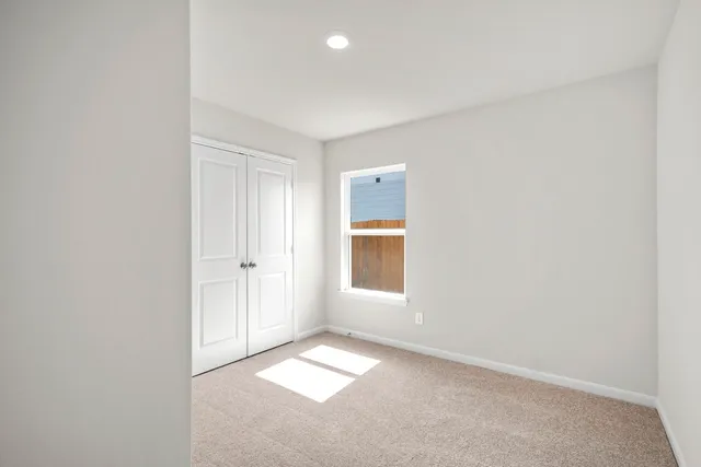an empty room with a window and closet