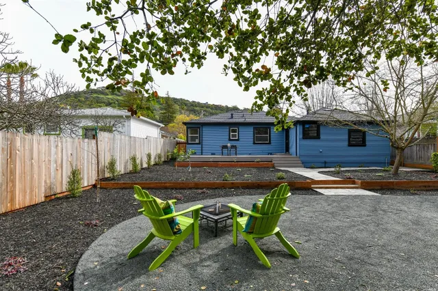 a view of a house with backyard and sitting area