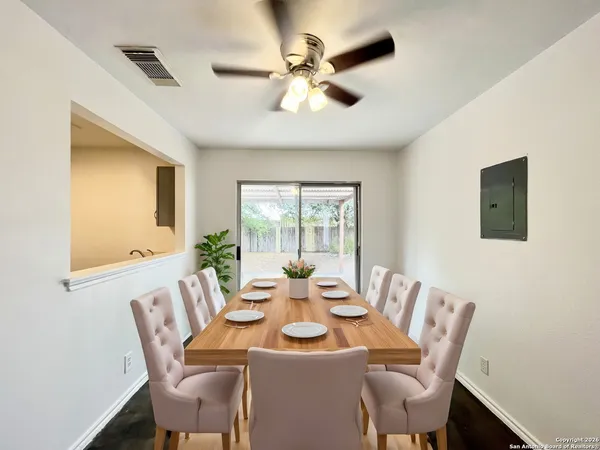 a dining room with furniture a large window and wooden floor