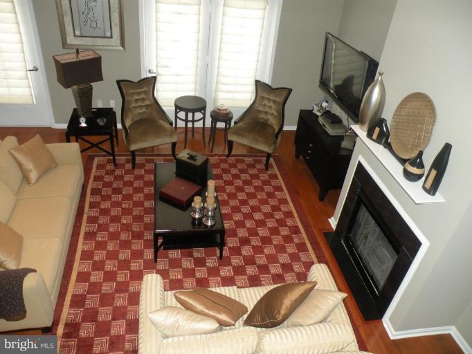 12000 Market Street, Unit 438 Reston, VA 20190 - Photo 1 of 13 a living room with furniture and a fireplace