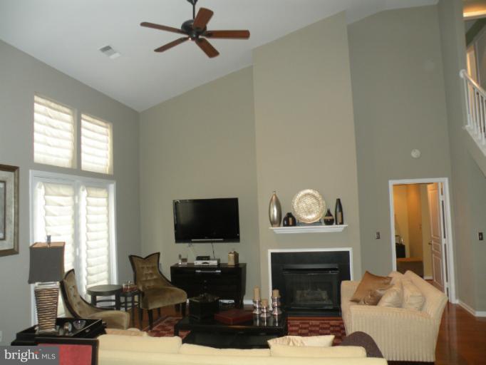 12000 Market Street, Unit 438 Reston, VA 20190 - Photo 6 of 13 a living room with furniture a fireplace and a flat screen tv