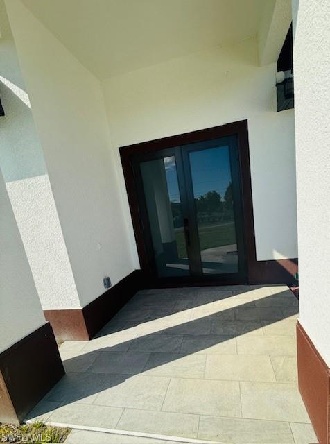 165 Patio Street Lehigh Acres, FL 33974 - Photo 5 of 34 View of exterior entry with french doors and stucco siding