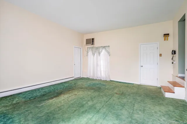 a view of an empty room with closet and a window