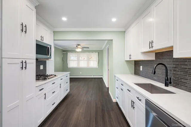 a kitchen with granite countertop a sink stove and cabinets