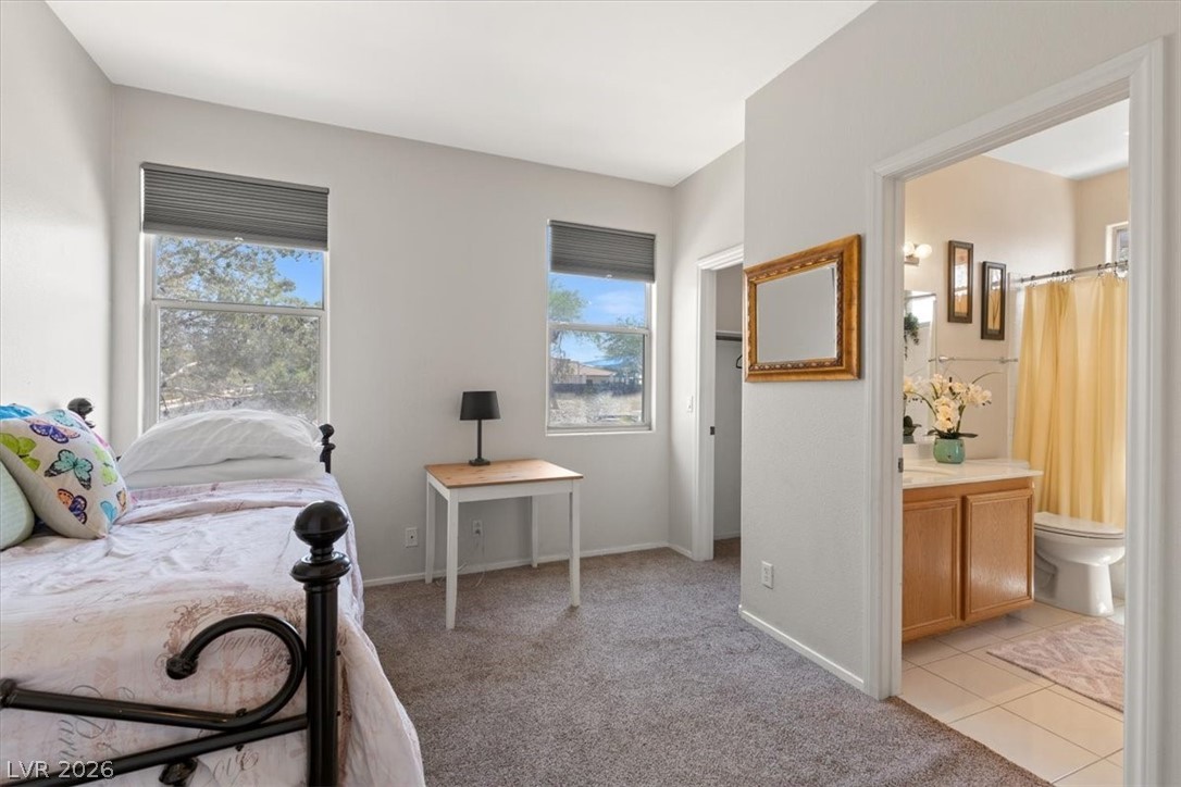 2377 Ramsgate Drive Henderson, NV 89074 - Photo 20 of 25 A well-lit bedroom with soft carpeting connects seamlessly to a tiled private bathroom.