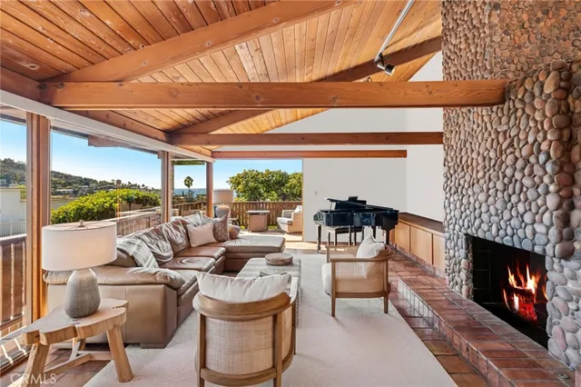 a living room with furniture a fireplace and a floor to ceiling window