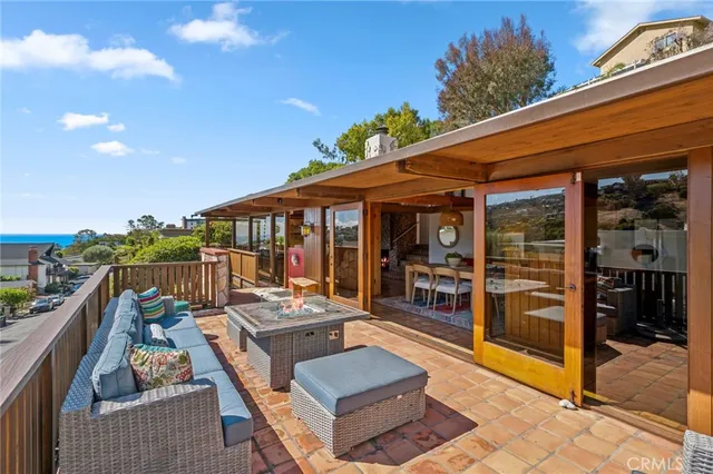 a view of a patio with couches table and chairs with wooden floor
