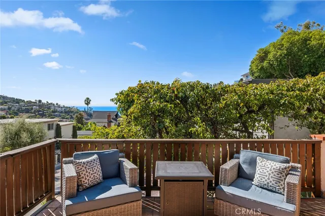 a view of a roof deck with couches and sky view