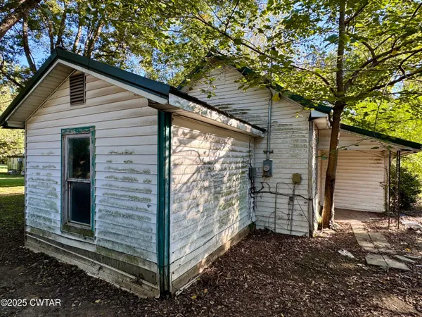a view of a small house with large tree