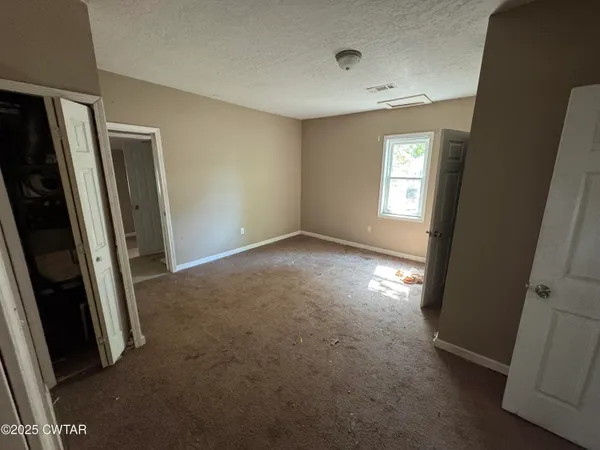 an empty room with windows and closet
