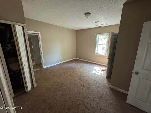 an empty room with windows and closet